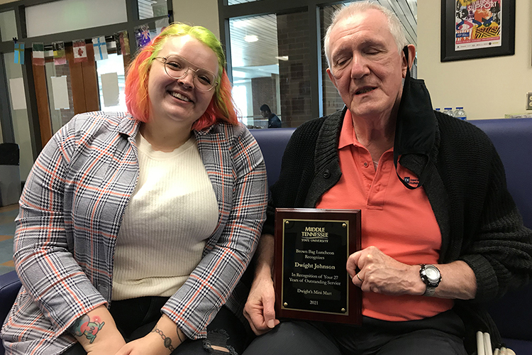Miranda Johnson, left, helps her father, Dwight Johnson, proprietor of Dwight's Mini Mart, celebrate 27 years of service to the MTSU community at an Oct. 25 ceremony at the Student Union. Johnson, who has been blind most of his life, runs the convenience store in Keathley University Center. October is National Disability Employment Awareness Month. (MTSU photo by Gina Logue)