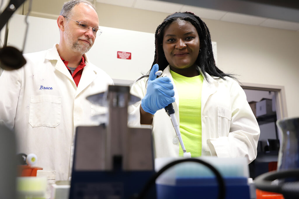 Dr. Bruce Cahoon, left, UVA Wise John C. Buchanan Endowed Chair of Biology, oversees senior Humbertine Moyo of Zambia working on a project in the college’s research lab. In a partnership with MTSU’s International Ginseng Institute and other schools, Cahoon will coordinate soil analysis, exploring best practices in organic ginseng growth and prevention of fungal disease to promote rural sustainable farming. He is a former MTSU biology professor. (Photo by UVA Wise)