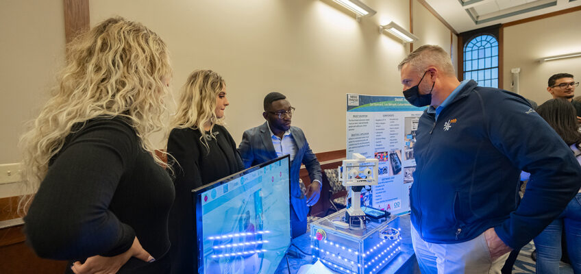 Competition judge Jeff Mech, right, listens as MTSU students Zani, left, and Lee Barnard and Jordan Pufon explain their project in the recent MTSU Engineering & Technology Mech-Tech Expo, held in the Ingram Building’s MT Center. The expo showcases students’ work during the fall 2021 semester. (MTSU photo by Cat Curtis Murphy)