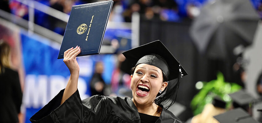 A graduating senior at MTSU's fall 2021 commencement ceremonies shouts with joy while she shows her new degree to supporters in the stands in Murphy Center Saturday, Dec. 11. The university presented degrees to more than 1,670 students in three commencement events to conclude the fall semester. (MTSU photo by J. Intintoli)