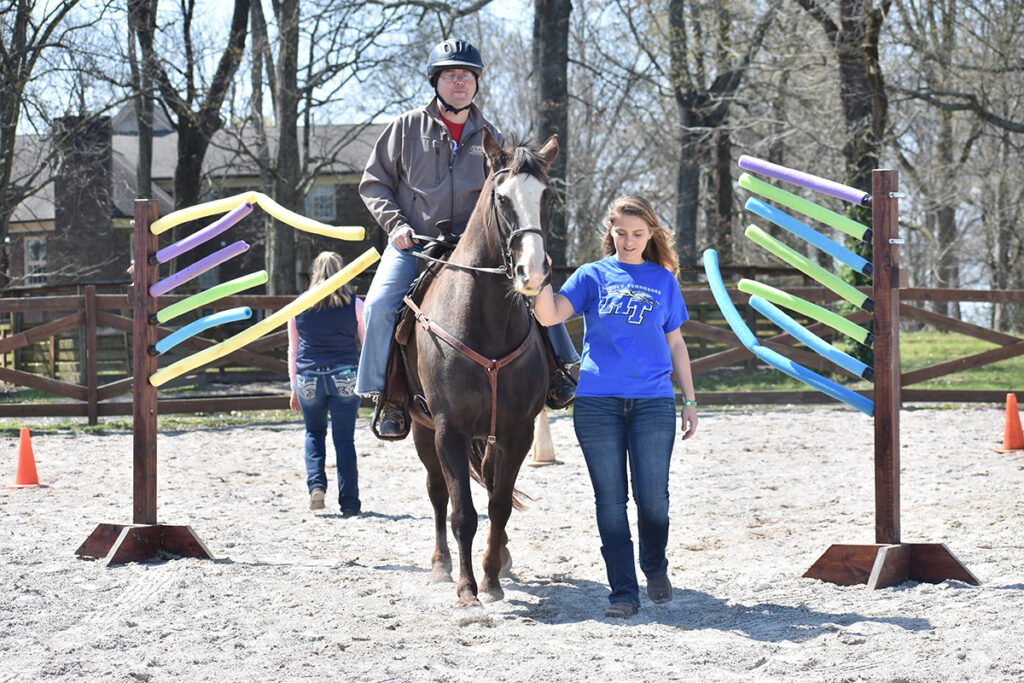 Led by an MTSU horse science student mentor, a participant the Center of Equine Recovery for Veterans rides a horse named Floyd during a therapy session. The seventh annual MTSU CERV Spring Spectacular Horse Show will be held starting at 8 a.m. Sunday, April 3, in the main arena of the Tennessee Livestock Center, 1720 Greenland Drive, and benefits the veterans therapy program. (MTSU photo by Ashley Gallagher)