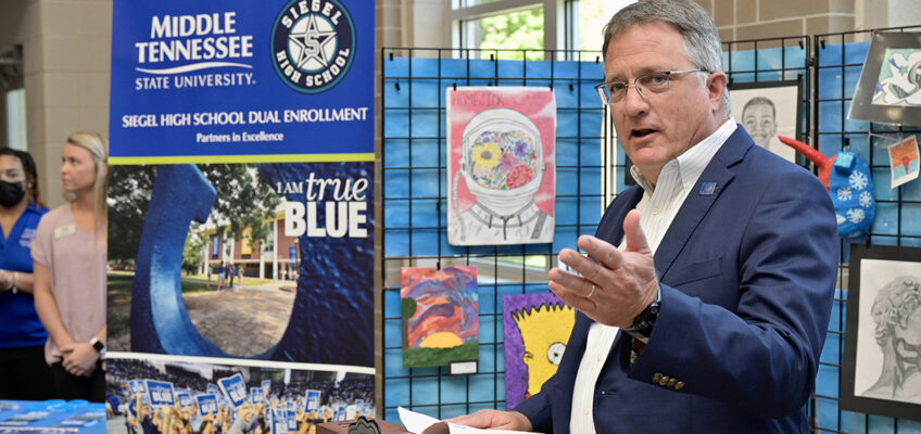 Standing before a display of student art work, MTSU Provost Mark Byrnes touts the success of the Siegel Humanities Academy, a collaboration between MTSU and Siegel High School, during an April 26 ceremony at Siegel. (MTSU Photo by Andy Heidt)