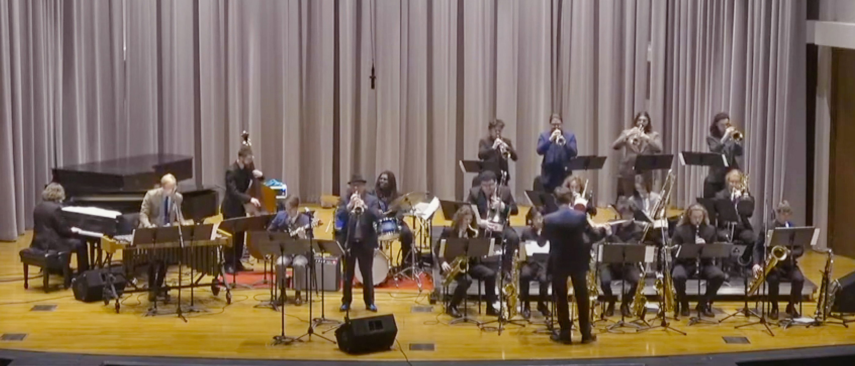 The MTSU Jazz Ensemble I, the School of Music's top jazz student performing group, winds up the annual Illinois Jacquet Jazz Festival April 2 on the stage of Hinton Hall in the Wright Music Building with two-time Grammy-winning jazz trumpeter Brian Lynch, standing center left by the monitor, as Jazz Studies Program director Jamey Simmons, leads the group at right. The MTSU ensemble will perform Saturday, May 7, at 1:30 p.m. at Murfreesboro's 25th annual JazzFest downtown on the Public Square. (image courtesy of MTSU School of Music livestream)
