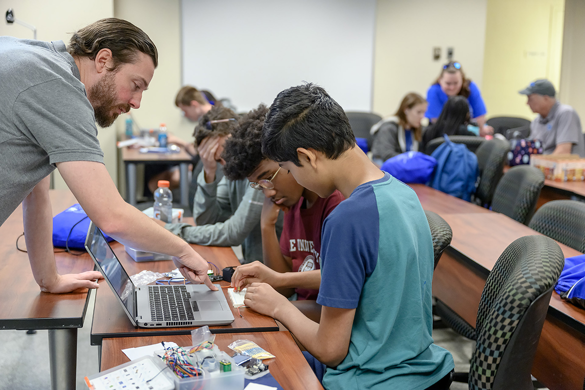 MTSU Engineering Technology electronics lab director Daniel Garrett, left, works with high school sophomores Daniel Morgan of Spring Hill, Tenn., second from left, Miles Minor of Murfreesboro and Vishnu Channagiri of Franklin, Tenn., in this July 2022 photo taken in a Voorhies Engineering Technology classroom. The students were making solar panels out of circuit boards during the College of Basic and Applied Sciences Summer STEM Camp. Registration begins Wednesday, March 15, for the 2023 camp open to 90 rising ninth through 12th-grade students. (MTSU file photo by J. Intintoli)