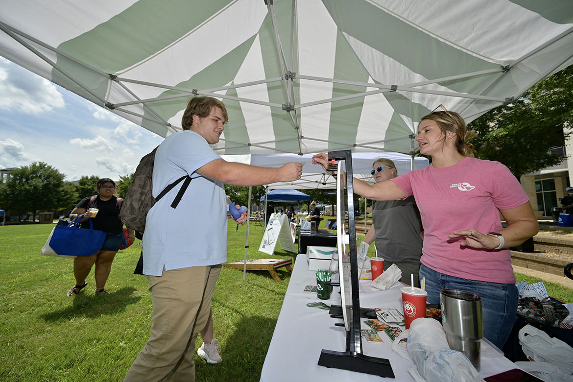 William Smith, 18, left, an MTSU freshman Concrete Industry Management major from Memphis, Tenn., receives a card for a free box of doughnuts from Murfreesboro Donut Country owner Kristy Davis Tuesday, Aug. 23, during the annual Meet Murfreesboro event in the Student Union Commons. At Meet Murfreesboro, new and returning students can learn about a variety of local businesses, including restaurants, and what they have to offer. (MTSU photo by Andy Heidt)