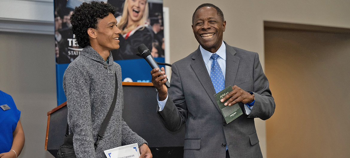 Prospective Middle Tennessee State University student Ty Drake, left, speaks to the crowd after winning a $1,000 scholarship from University President Sidney A. McPhee, right, at MTSU’s True Blue Tour event at the Millennium Maxwell House in Nashville, Tenn., on Wednesday, Oct. 5, 2022. (MTSU photo by James Cessna)