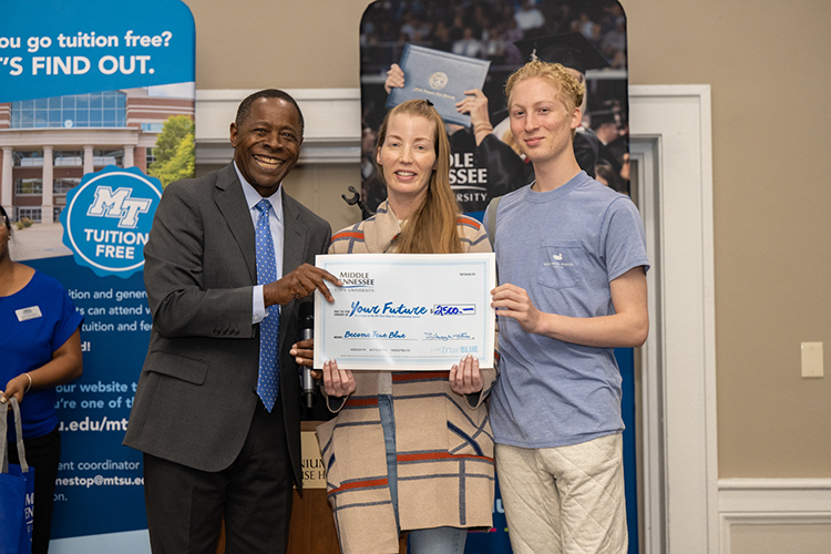 Prospective Middle Tennessee State University student Peyton Fontenot, right, poses with his mother Jamie Fontenot, center, and University President Sidney A. McPhee after winning a $2,500 scholarship at the True Blue Tour event at the Millennium Maxwell House in Nashville, Tenn., on Wednesday, Oct. 5, 2022. (MTSU photo by James Cessna)