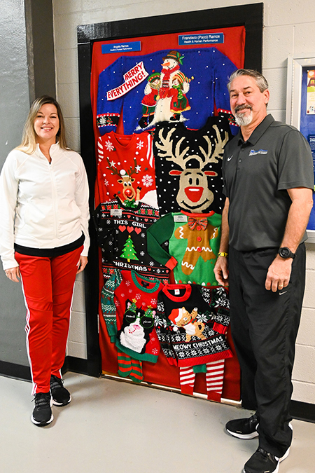 Middle Tennessee State University Health and Human Performance faculty Paco Ramos, right, and his wife and coworker Angela Ramos, thrifted and sewed together their ugly Christmas sweater door décor as part of the department’s holiday door décor competition and posed with their creation on Wednesday, Nov. 30, 2022, at the Murphy Center on campus. (MTSU photo by Stephanie Wagner)