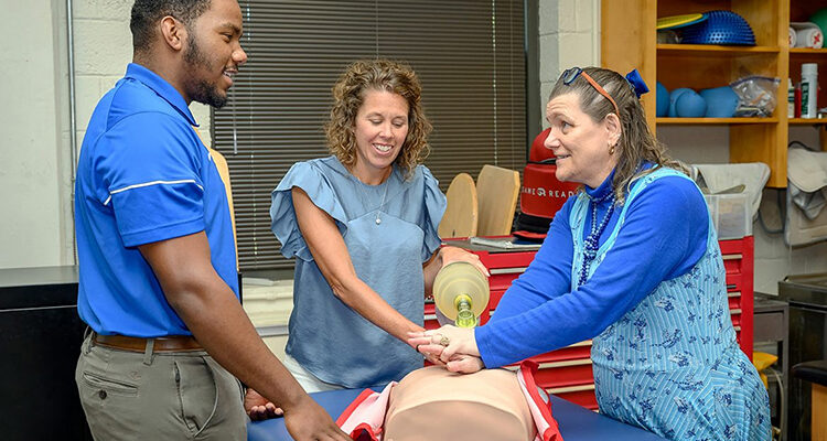Helen Binkley, right, director of the Athletic Training master’s program at Middle Tennessee State University, and Kristi Phillips, the program’s coordinator, demonstrate a CPR technique to then student Nick Smith, now an MTSU graduate, in the summer of 2021 on campus. (MTSU file photo by J. Intintoli)