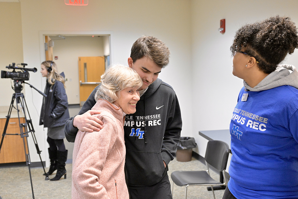 Carol Detmer, left, receives a hug from Andrew Scrugham as Jasmine Jackson observes Friday, Feb. 9, in a Middle Tennessee State University Health, Wellness and Recreation Center second-floor conference room. Scrugham and Jackson were two of four Campus Recreation Center student workers who quickly responded when Richard Detmer experienced cardiac arrest while playing racquetball Jan. 19 in the rec center. The Detmers brought cookies to thank the students for helping save his life. (MTSU photo by Andy Heidt)