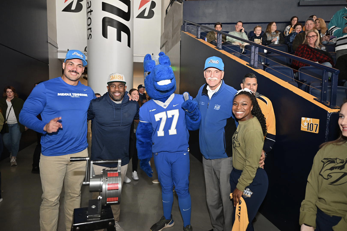 Derek Mason, second from left, Middle Tennessee State University Blue Raiders football coach, visits with fans during the Preds True Blue Night/Military Appreciation event during the NHL Nashville Predators' game March 19 against the San Jose Sharks at Bridgestone Arena in Nashville, Tenn. Mason served as a fan captain before the start of the game. (MTSU photo by James Cessna)
