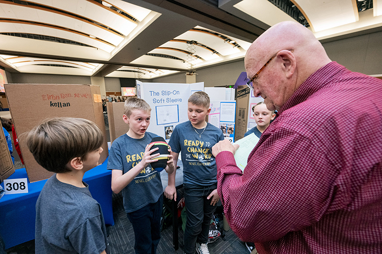 Middle Tennessee State University recently hosted its Invention Conventions — one for elementary and one for middle school students — in February 2024 in the Student Ballroom, bringing students from across the Midstate to campus to showcase their range of creative, innovative inventions. Mark Wilson, right, an event judge, listens to a ground of students present their project. (MTSU photo by Andy Heidt)