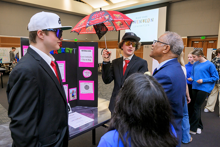Middle Tennessee State University education professor Donald Snead, far right, listens to a student presentation at the inaugural Middle School Invention Convention in the Student Union Ballroom on Feb. 27, 2024. The middle school event is an offshoot of the annual Invention Convention put on by the College of Education the past three decades to bring students to campus from across the Midstate to showcase their range of creative, innovative inventions with the campus community. (MTSU photo by Andy Heidt)