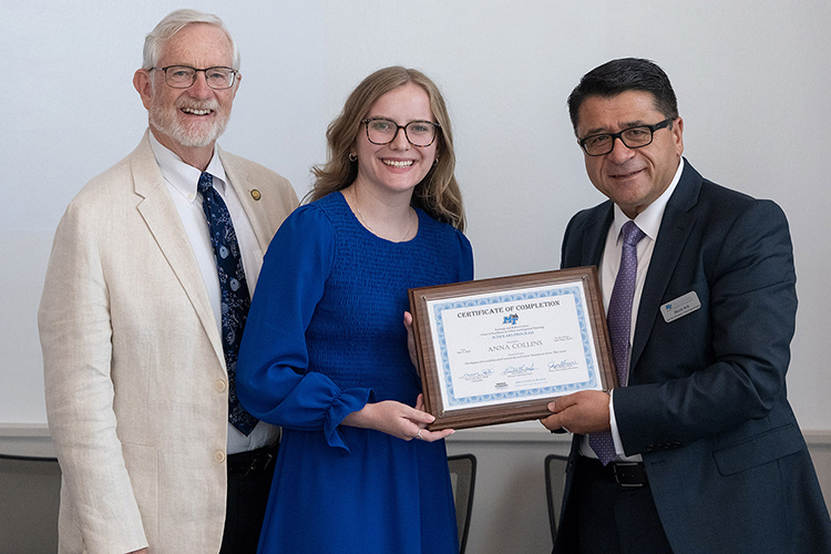 Middle Tennessee State University student Anna Collins, an agribusiness major from Pleasant View, Tenn., second from left, receives her certificate of completion May 3 as part of the inaugural cohort of the Chair of Excellence in Urban and Regional Planning Scholars Program in the Jones College of Business. This year’s program concluded with the scholar presentations inside the Academic Classroom Building on the MTSU campus in Murfreesboro, Tenn. Presenting the certificate is chairholder Murat Arik, right, and Paul Martin Jr., chair of the COE-URP advisory committee. (MTSU photo by Andy Heidt)