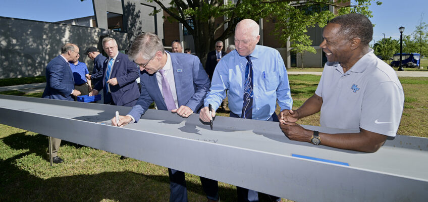 Middle Tennessee State University College of Basic and Applied Sciences Dean Greg Van Patten, left, and Engineering Technology Chair Ken Currie sign the final steel beam as MTSU President Sidney A. McPhee smiles in the brief Applied Engineering Building topping out ceremony Wednesday, May 1, next to the School of Concrete and Construction Management Building on the MTSU campus in Murfreesboro, Tenn. The building will house the Mechatronics Engineering program and other Engineering Technology concentrations. (MTSU photo by J. Intintoli)