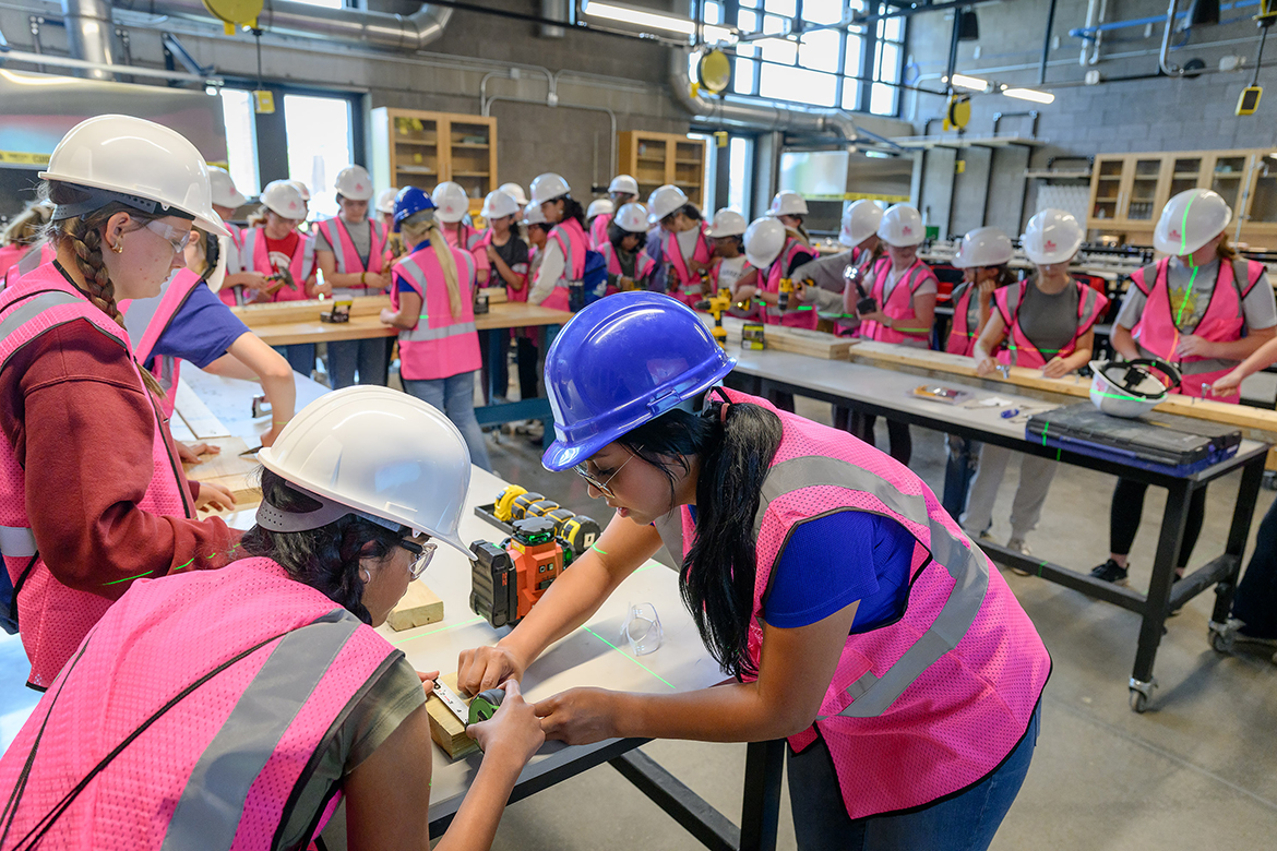 Aarna Suman, left, of Murfreesboro, Tenn., a rising Central Magnet School eighth grader, receives help measuring a wood block from Middle Tennessee State University senior Concrete Industry Management major Jennie Love, during a featured session at the CIM Patron-sponsored Ladies in Concrete event in early May in the School of Concrete and Construction Management Building on campus in Murfreesboro. Girls from four Rutherford County middle schools and six area high schools participated in the four-hour event. (MTSU photo by J. Intintoli)