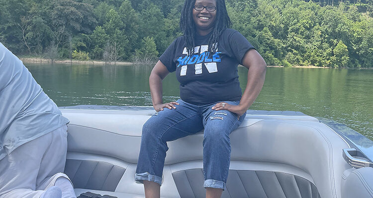 In this undated photo, Denise Weeden, a May 2023 graduate from Middle Tennessee State University in Murfreesboro, Tenn., shows off her MTSU pride with a branded T-shirt during a family lake outing. An employee with McGuire Restaurant Group, which operates multiple McDonald’s restaurants in the area, Weeden earned a promotion just two months after earning her degree thanks to a partnership between McGuire and MTSU that allows McGuire employees to attend MTSU at a discounted rate. (Submitted photo)