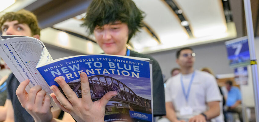 A new student planning to start his college career at Middle Tennessee State University this fall browses through the New to Blue Orientation brochure provided to attendees May 20 in the Student Union Ballroom on campus in Murfreesboro, Tenn. (MTSU photo by J. Intintoli)