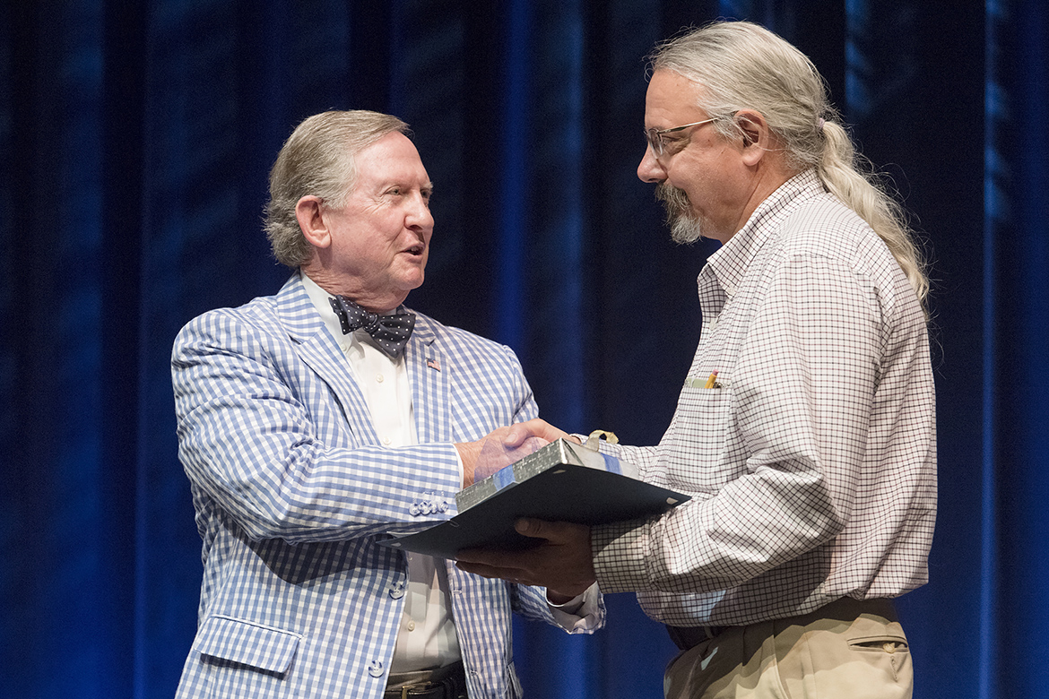 MTSU alumnus Ron Nichols, left, vice president of the MTSU Foundation, presents the foundation’s Career Achievement Award to Kevin E. Smith during the Fall Faculty Meeting held Thursday, Aug. 24, inside Tucker Theatre. Smith is a nationally recognized professor of anthropology at MTSU since 1994 and the founder and director of MTSU’s anthropology program in the Department of Sociology and Anthropology in the College of Liberal Arts. (MTSU photo by Andy Heidt)