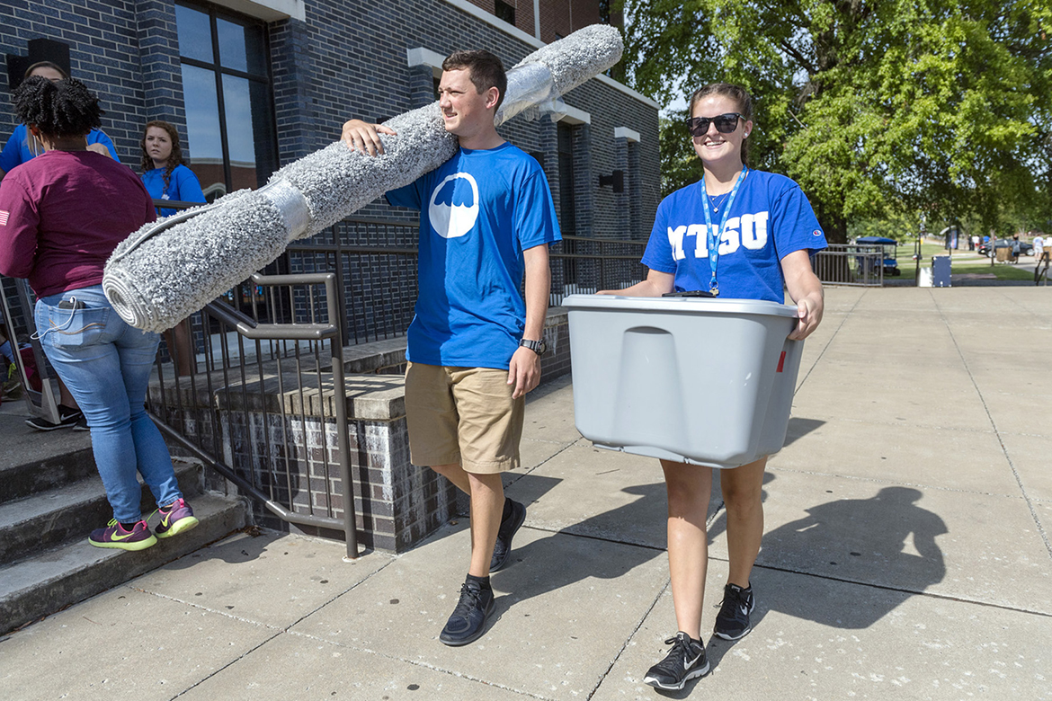 MTSU student Josh Potter, left, carries in a rug for MTSU freshman Bailey Hutchison, right, of White House, Tenn., Aug. 25, during We-Haul move-in on campus. (MTSU photo by Kimi Conro)