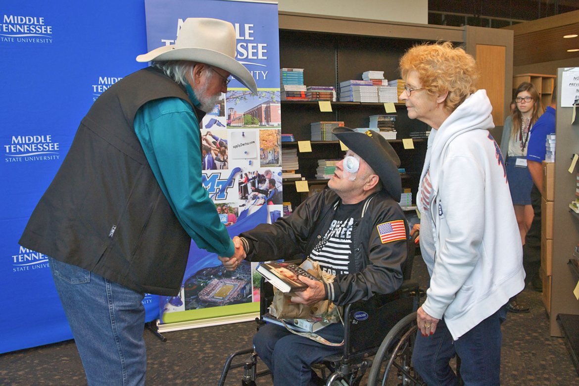 Country Music Hall of Fame inductee Charlie Daniels, left, greets a veteran and his wife who had purchased Daniels’ memoir, “Never Look at Empty Seats,” Nov. 2 inside Phillips Bookstore on the MTSU campus. Daniels signed copies of his book, which was released Oct. 24. (MTSU photo by J. Intintoli)