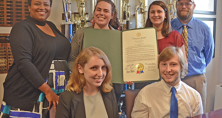 Some of the members of the Blue Raider Debate team are shown inside their office in Jones Hall with the Tennessee Senate Joint Resolution presented to the team earlier this year. Pictured are, seated front row from left, Jordan Nickell, a junior interactive media and sociology major from Jackson, Tenn.; and Alex Fingeroot, a religious studies, political science and history major from Tallahassee, Fla. Back row, from left, are Natonya Listach, assistant coach and instructor in communication studies and organizational communication; Katelyn Brooks, a senior communication studies and anthropology major from Nashville; Skye Irish, a senior political science major from Rockwood, Tenn.; and Pat Richey, debate team coach and director of forensics at MTSU. (MTSU photo by Jimmy Hart)