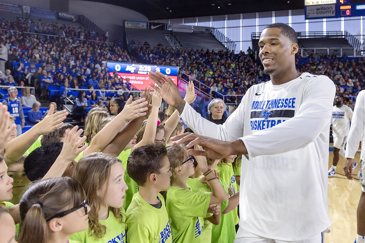 Rockvale Chorus members high five an MTSU player after singing the national anthem.
