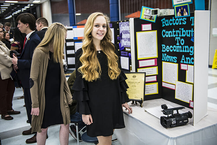 Blackman High School senior Cheyana Avilla stands next to her research project display during the Feb. 8 Blackman Collegiate Academy Capstone Gallery Walk in the school’s cafeteria. Avilla plans to attend MTSU and major in multimedia communicatons. (MTSU photo by Eric Sutton)