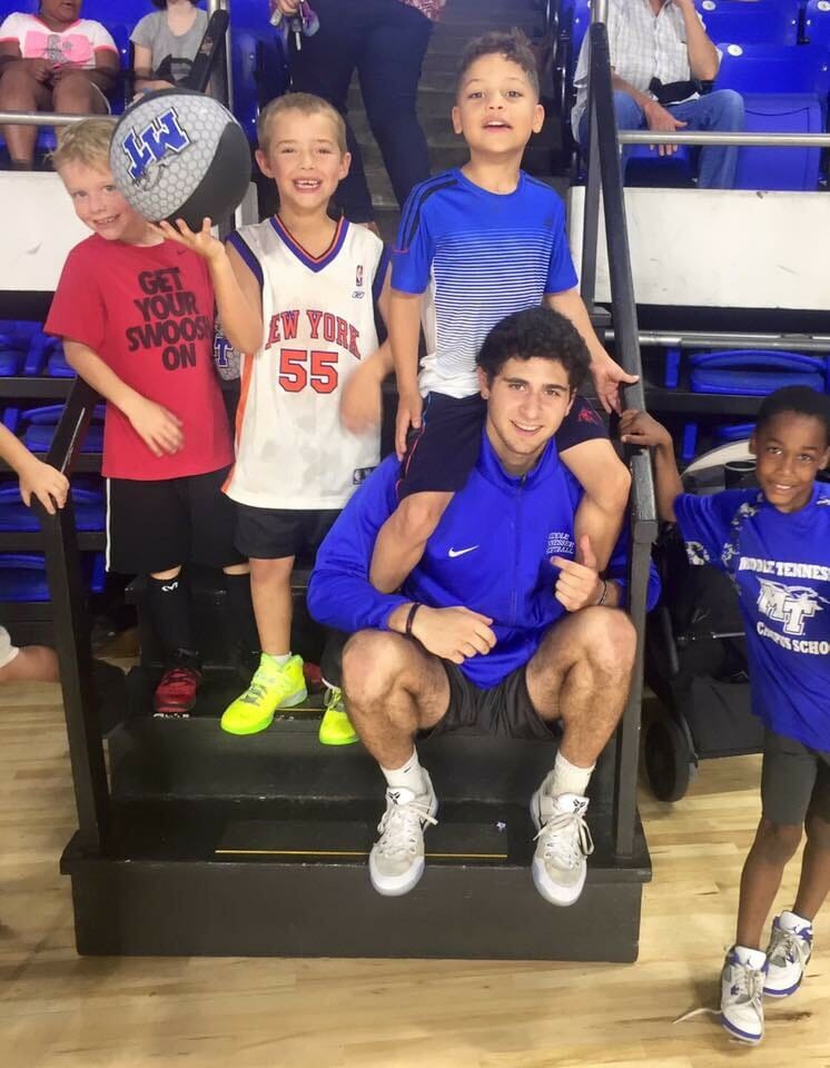 Chase Miller poses with kids at Murphy Center.