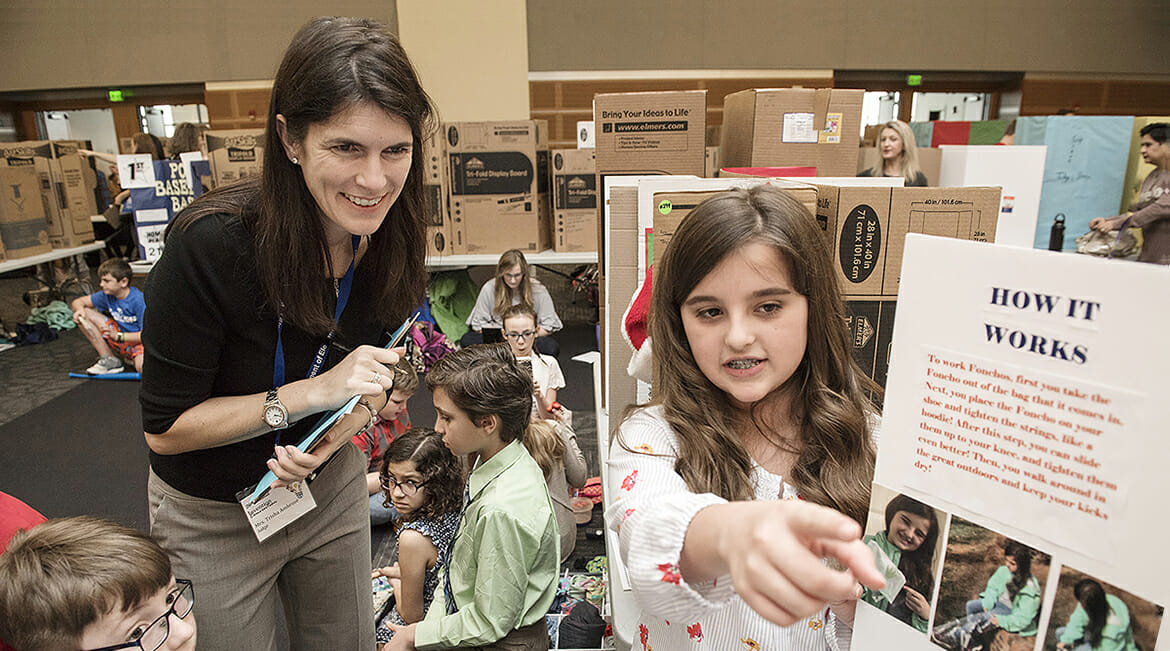 Trisha Ambrose of Accenture Inc., left, a guest judge at MTSU's 26th annual Invention Convention, listens to fifth-grader Grace Woods discuss her invention, 