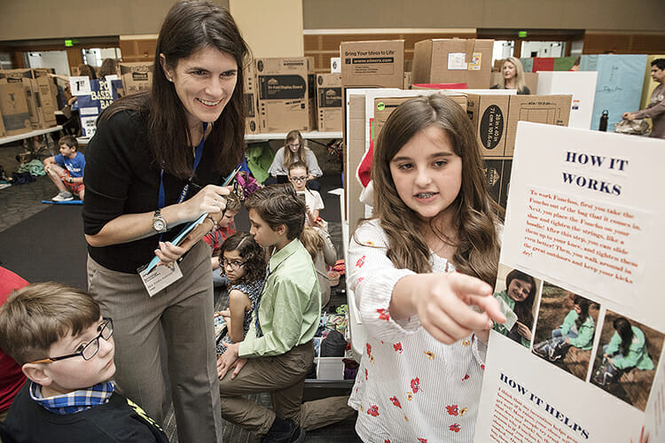 Trisha Ambrose of Accenture Inc., left, a guest judge at MTSU's 26th annual Invention Convention, listens to fifth-grader Grace Woods discuss her invention, "Fonchos," which "make life easier" by protecting shoes and pants from weather. Woods, who attends Dr. William Burrus Elementary School in Hendersonville, Tenn., was one of more than 800 fourth-, fifth- and sixth-graders participating in the event in MTSU's Student Union Ballroom. (MTSU photo by Andy Heidt)