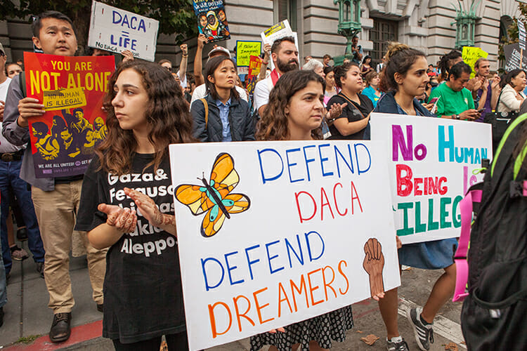 Protesters hold signs and banners at a September 2017 rally in support of the Deferred Action for Childhood Arrivals policy in San Francisco. (Photo by Pax Ahimsa Gethen/Wikipedia)
