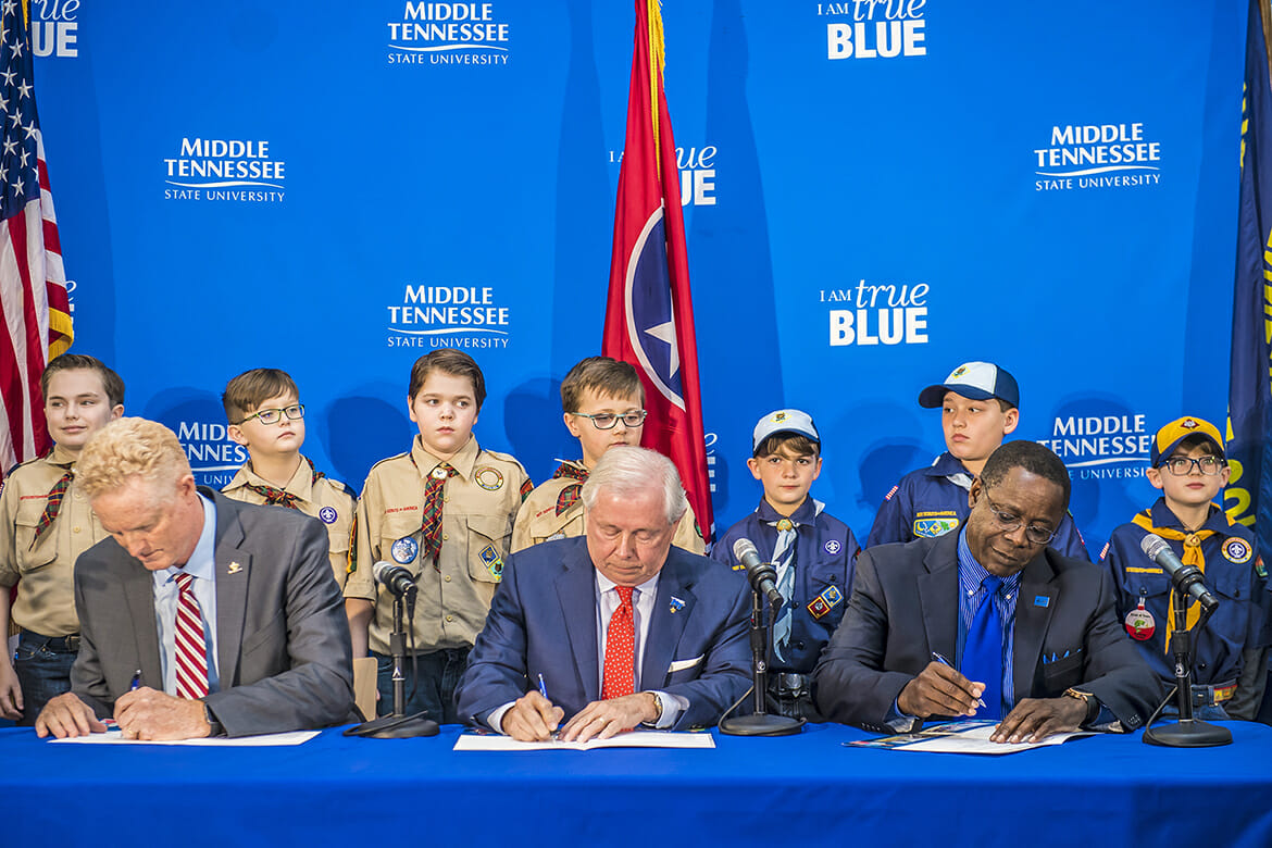 MTSU President Sidney A. McPhee, right, joins Larry Brown, left, CEO of the Middle Tennessee Council of the Boy Scouts of America, and MTSU Trustee J.B. Baker, center, to sign a partnership Wednesday, March 7, in the Strobel Lobby at MTSU. Behind them in the lobby, which connects the Davis Science Building and Wiser-Patten Science Hall, are Cub Scouts from Scales and Rockvale elementary schools. The agreement allows the university to be a greater resource for scouting programs, particularly in science and technology. (MTSU photo by Eric B. Sutton)
