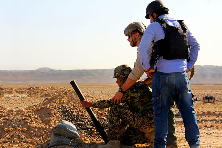 U.S. contractors, right, observe as an Afghan soldier prepares to load a round during mortar training taught by the Warrior Training Alliance on Tactical Base Gamberi, Afghanistan, in this December 2014 photo. U.S. soldiers provided security during the training. MTSU history professor Suzanne Sutherland has received a National Endowment for the Humanties grant to study military contractors during the 17th century and how their work affects nations today. (U.S. Army photo by Capt. Jarrod Morris)