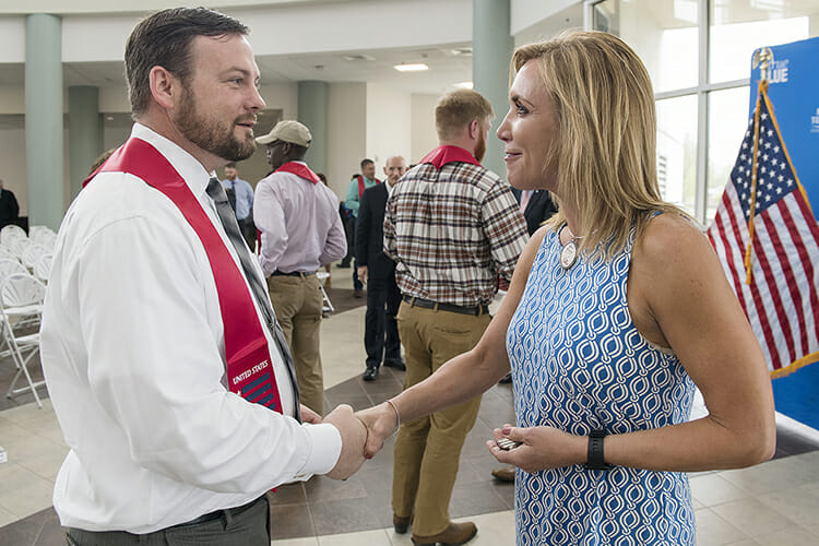 Andrew Littlefield, left, an MTSU student veteran planning to graduate in May, receives a congratulatory handshake from Hilary Miller, director of the Charlie and Hazel Daniels Veterans and Military Family Center. The interaction occurred April 25 during the Graduating Veterans Stole Ceremony in the Miller Education Center. (MTSU photo by Andy Heidt)