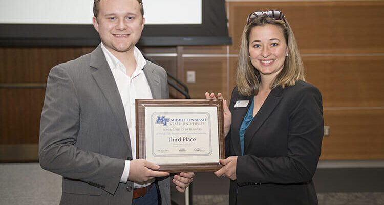 MTSU senior entrepreneurship major Evan Hemontolor, left, accepts his third-place plaque for event organizer Stacy Aaron during the April 25 Business Plan Competition Finals hosted by the Jones College of Business’ Pam Wright Chair of Entrepreneurship. (MTSU photo by Eric Sutton)