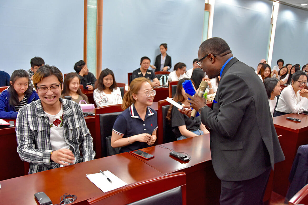 MTSU President Sidney A. McPhee gives True Blue gear to two students who answered a question he posed during his lecture Wednesday, May 9, at North China University of Technology in Beijing about American culture. (MTSU photo by Andrew Oppmann)