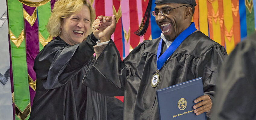 MTSU graduate Tyree Rumph receives congratulations from Pat Thomas, administrative assistant to the Board of Trustees, after receiving his degree in liberal studies during the December 2017 afternoon commencement ceremony inside Murphy Center. (MTSU file photo by Kimi Conro)