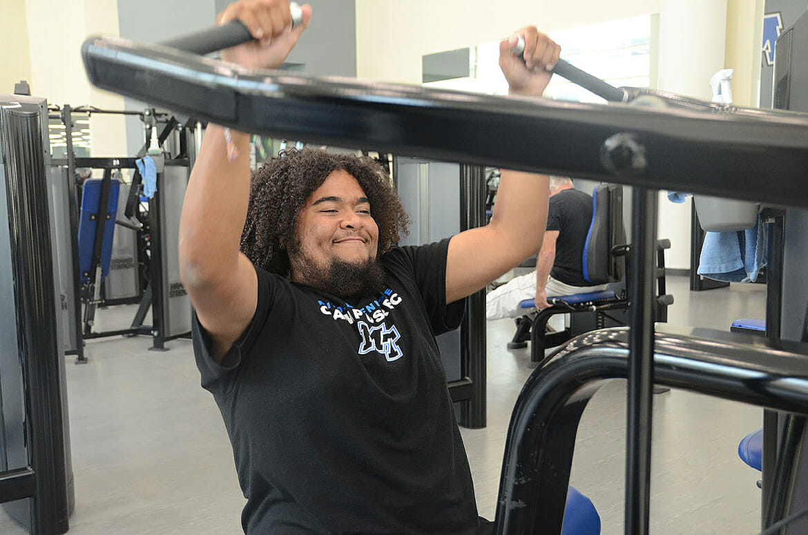 MTSU senior Caleb King of Manchester, Tenn., a supervisor in the weight room inside the MTSU Student Health, Wellness and Recreation Center, works out on one of the Rec’s chest press machines as he moves closer toward reaching his 100-pound weight loss goal. (MTSU photo by K. Simpson)