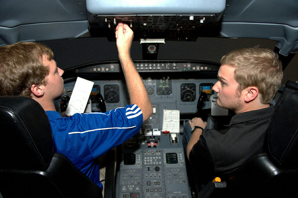 Then-MTSU seniors Kevin Allsop of Knoxville, Tenn., left, and Charles Greenfield of Kingsport, Tenn., check the view from the cockpit of the flight simulator during the May 2016 dedication of the Flight Simulator Building at Murfreesboro Airport. In August, Delta’s Collegiate Pilot Career Path will begin accepting applications to find the next generation of pilots. (MTSU file photo by J. Intintoli)