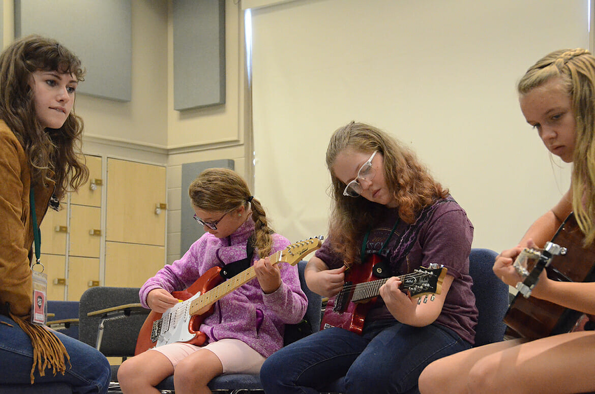 From left, Southern Girls Rock Camp volunteer band manager Leanih Chestnut instructs campers Emma Thornhill, 11; Alice Morgan, 12; and Addy Stembridge, 12. In its 16th year, the camp was held July 23-28 at Middle Tennessee State University. (MTSU photo by K. Simpson)