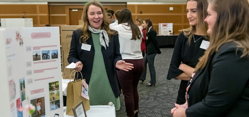 Summit High School student Ally Losey, left, explains her Singulier Clothing Company idea Nov. 14 during the High School Entrepreneurship Fair in the Student Union Ballroom as part of Global Entrepreneurship Week at MTSU. Losey won first place overall at the fair, which allowed high school students to showcase their business plans and ideas with displays and presentations. (MTSU photo by J. Intintoli)
