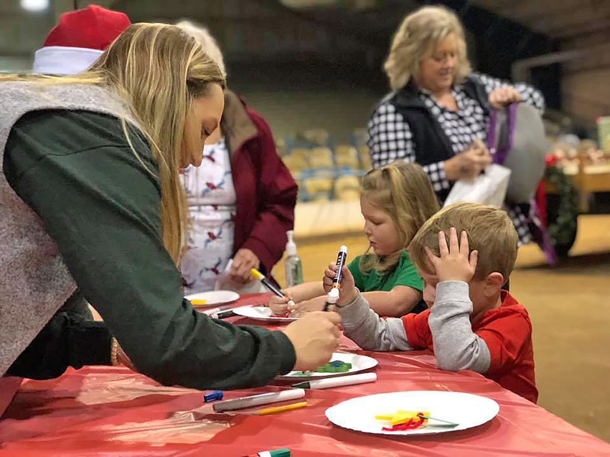 An MTSU agritourism class member assists a little boy in making a Christmas craft during the annual Winter Village, formerly called Christmas Village, held in December 2018 in the Tennessee Livestock Center. This year’s event will be held from 9 a.m. to noon on Saturday, Dec. 7. (Submitted photo)
