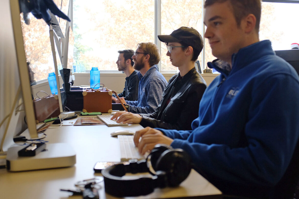 Student workers in the Office of Marketing & Communications sitting at desks with computers in front of them producing lifestyle blog content for the MTSU Student Voice. Photo: John Goodwin