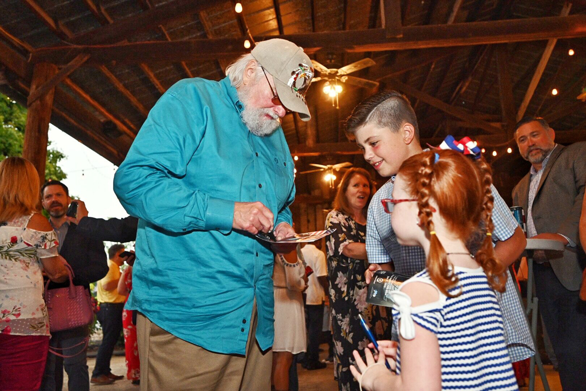 Country Music Hall of Fame member Charlie Daniels, left, signs autographs for two youngsters who attended the second Veteran Impact Celebration Thursday, June 27, at The Grove at Williamson Place. Daniels’ foundation, The Journey Home Project, gave the MTSU veterans center a $100,000 gift. (MTSU photo by J. Intintoli)