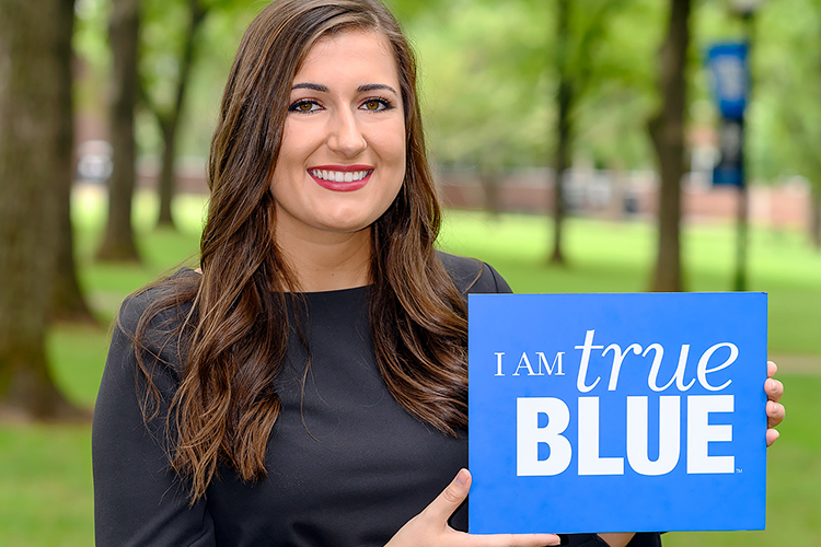 MTSU senior Delanie McDonald, the 2019-20 Student Government Association President, holds a True Blue sign in this photo taken at Walnut Grove. (MTSU photo by J. Intintoli)