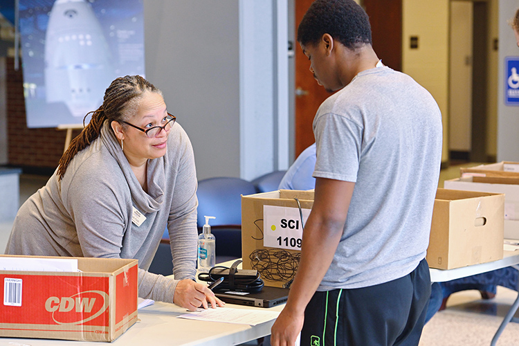 Yolonda Fields, left, administrative secretary for MTSU’s Information Technology Division, helps a student check out a laptop recently at the Cope Administration Building lobby. (MTSU photo by Cat Curtis Murphy)