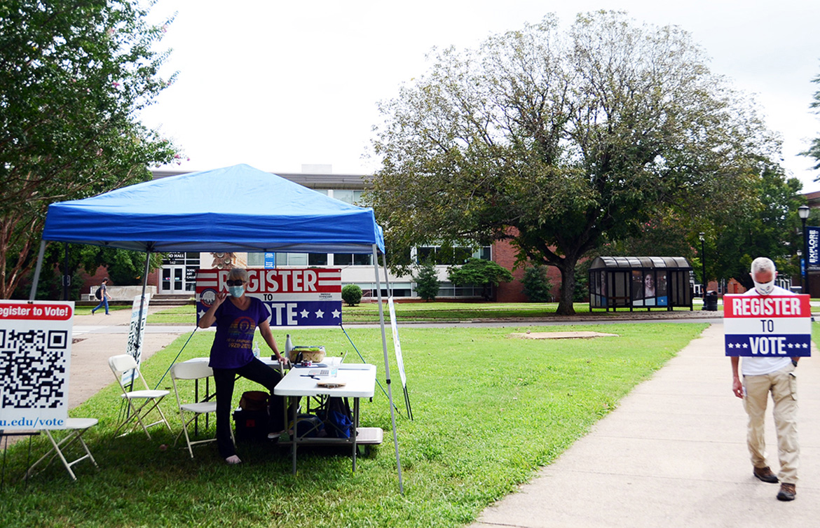 Retired Army Maj. Steve Daugherty, right, awaits members of the campus community outside the American Democracy Project’s voter registration tent on the south side of MTSU’s Peck Hall. Volunteer and MTSU alumna Lee Anne Carmack of the Murfreesboro chapter of the American Association of University Women is under the awning. (MTSU photo by Gina Logue)