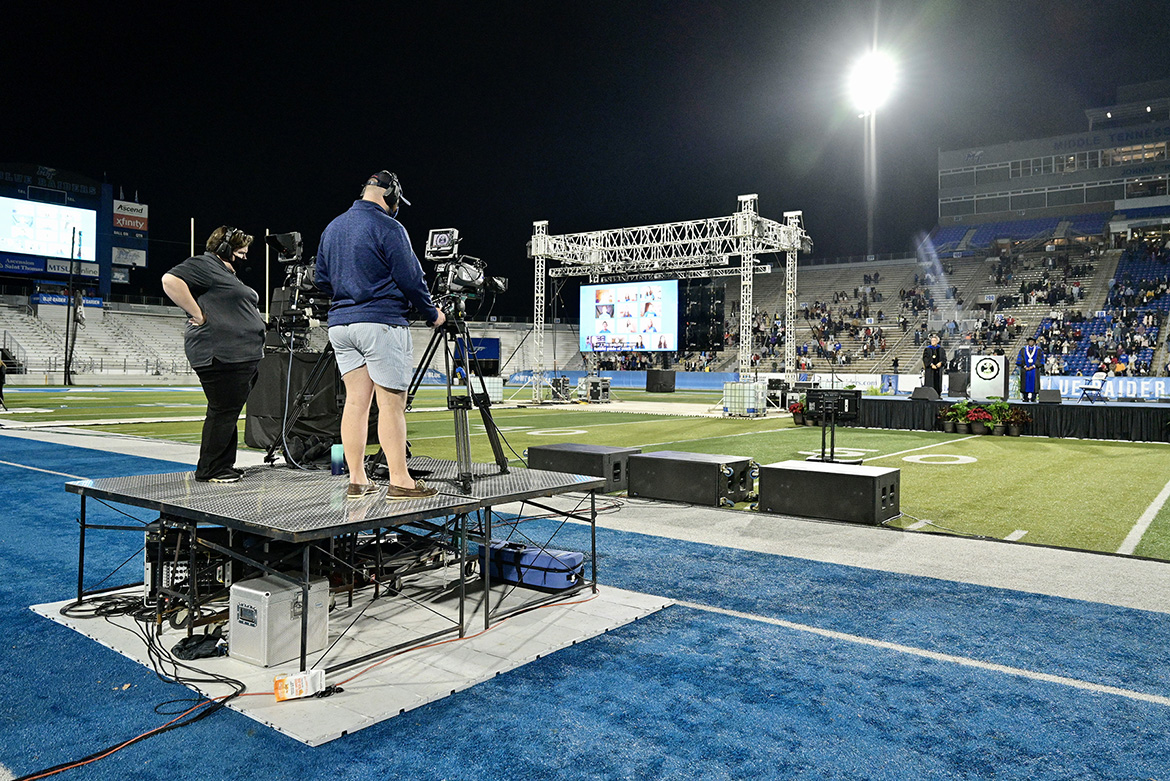 At right on stage, MTSU President Sidney A. McPhee and Provost Mark Byrnes preside over the third livestreamed Fall 2020 commencement ceremony Saturday, Nov. 21, at Floyd Stadium. Students from the College of Media and Entertainment’s Department of Media Arts, as well as students working for the university’s Production Services team, produced the broadcast, which will re-air along with the two other ceremonies held earlier in the day, for 24 straight hours on Saturday, Nov. 28, on True Blue TV. (MTSU photo by Andy Heidt)