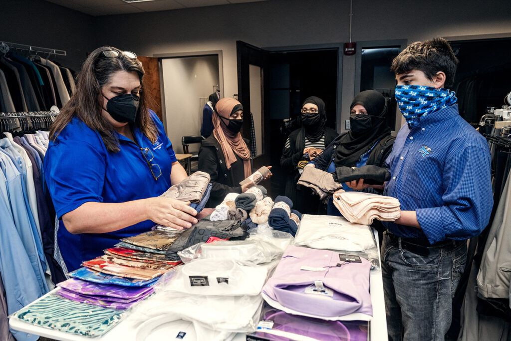 Kim Collins, left, executive aide in the MTSU Career Development Center, left, collects Muslim-friendly clothing items solicited by the Alnassari family — daughters, Zaynab and Fatima, mom Khadijah and son Ahmed. The triplets, now 15, are dual enrollment biology majors pursuing a premed pathway. They will have earned enough credits to be juniors this fall at MTSU. Khadijah Alnassari was named 2021-22 MTSU Student Organization President of the Year. (MTSU file photo by Andy Heidt)